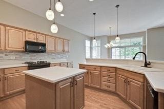 3942 Honeymoon Rdg, Lake In The Hills, IL 60156 - kitchen featuring black microwave, a center island, light wood finished floors, light countertops, and range