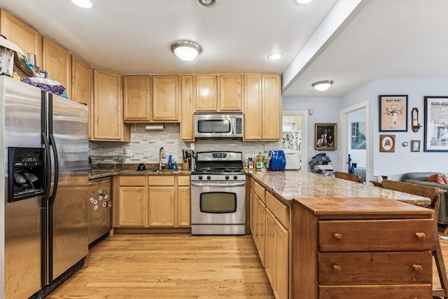 1214 W Early Ave Unit 1E, Chicago, IL 60660 - kitchen featuring appliances with stainless steel finishes, a peninsula, light wood-style flooring, light brown cabinets, and tasteful backsplash