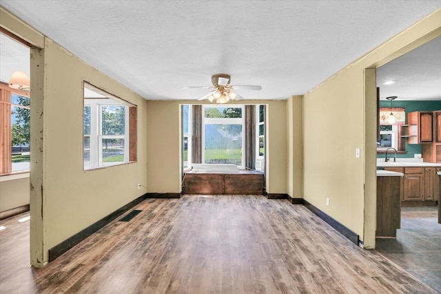 403 E Cooke St, Mount Pulaski, IL 62548 - unfurnished dining area with wood finished floors, a ceiling fan, and a textured ceiling