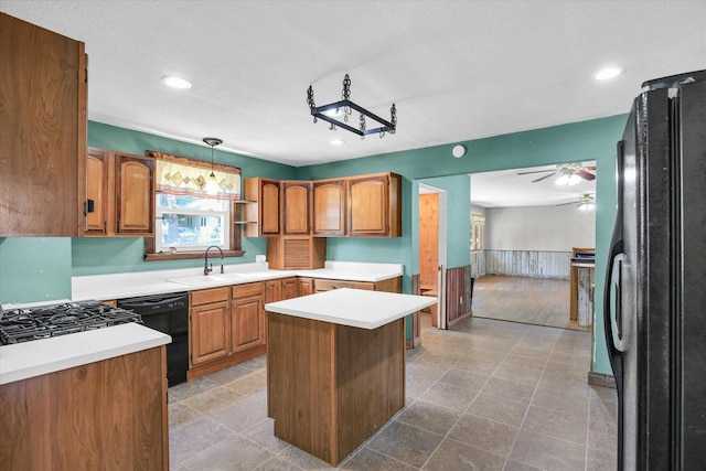 403 E Cooke St, Mount Pulaski, IL 62548 - kitchen with black appliances, ceiling fan, a center island, light countertops, and brown cabinetry