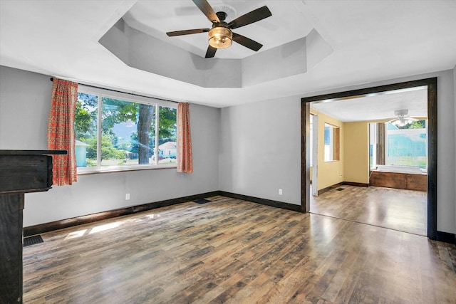 403 E Cooke St, Mount Pulaski, IL 62548 - spare room with wood finished floors, ceiling fan, and a raised ceiling