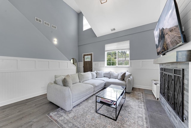 228 Juneway Ter, Lake Bluff, IL 60044 - living area featuring a towering ceiling, wood finished floors, a decorative wall, a fireplace with flush hearth, and wainscoting