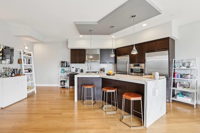 650 N Morgan St Unit 303, Chicago, IL 60642 - kitchen with appliances with stainless steel finishes, light wood finished floors, a kitchen breakfast bar, dark brown cabinets, and recessed lighting