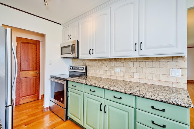 7033 N Kedzie Ave Unit 1706, Chicago, IL 60645 - kitchen with stainless steel appliances, light wood-style flooring, white cabinets, and decorative backsplash