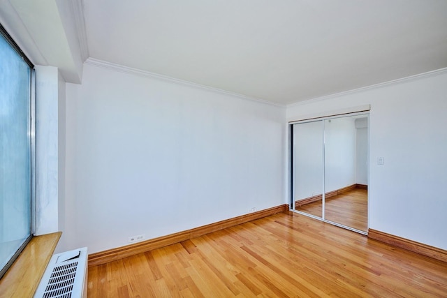 7033 N Kedzie Ave Unit 1706, Chicago, IL 60645 - unfurnished bedroom featuring wood finished floors, crown molding, and a closet