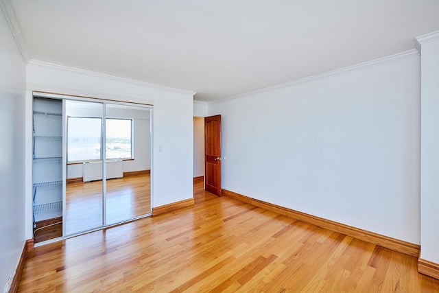 7033 N Kedzie Ave Unit 1706, Chicago, IL 60645 - unfurnished bedroom featuring ornamental molding, light wood-style flooring, and a closet