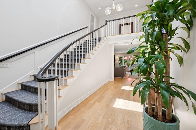 624 Laurel Ave, Wilmette, IL 60091 - stairway with wood finished floors, a chandelier, recessed lighting, and a towering ceiling