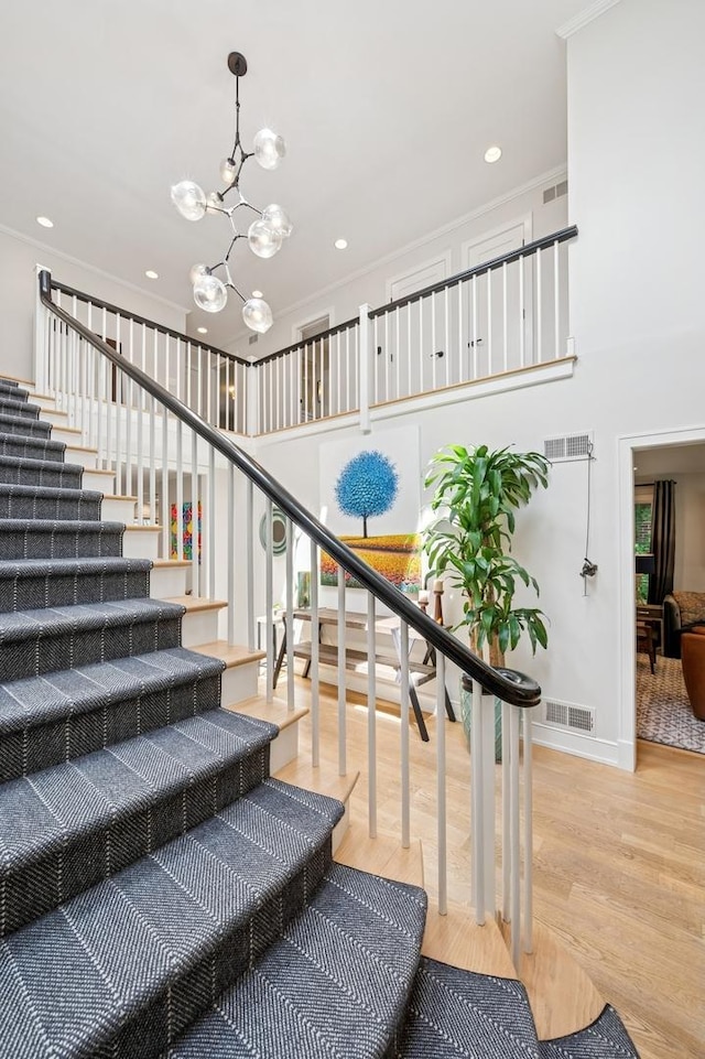 624 Laurel Ave, Wilmette, IL 60091 - stairway featuring a chandelier, wood finished floors, ornamental molding, recessed lighting, and a high ceiling