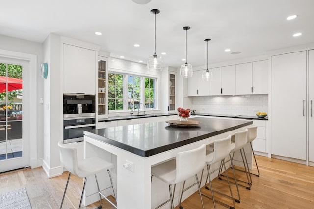 624 Laurel Ave, Wilmette, IL 60091 - kitchen featuring dark countertops, a breakfast bar, backsplash, plenty of natural light, and recessed lighting