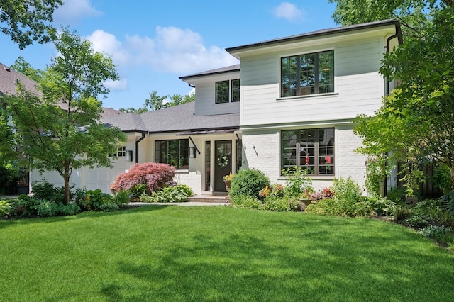 624 Laurel Ave, Wilmette, IL 60091 - view of front facade with an attached garage, a front yard, and roof with shingles