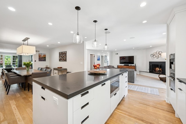 624 Laurel Ave, Wilmette, IL 60091 - kitchen with stainless steel microwave, dark countertops, light wood-type flooring, recessed lighting, and modern cabinets