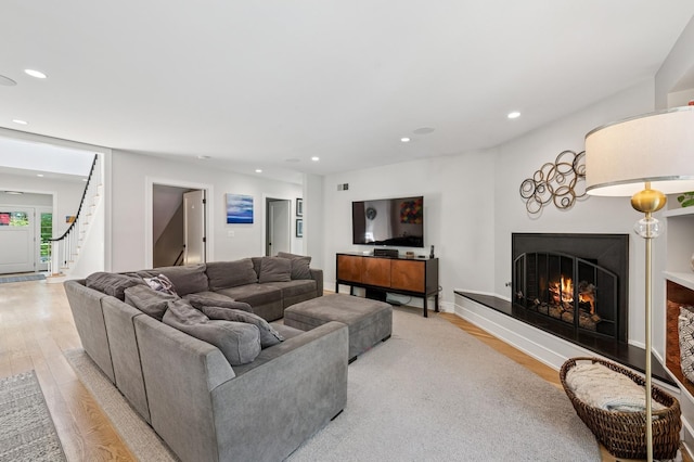624 Laurel Ave, Wilmette, IL 60091 - living room with light wood-style flooring, recessed lighting, a lit fireplace, and stairs