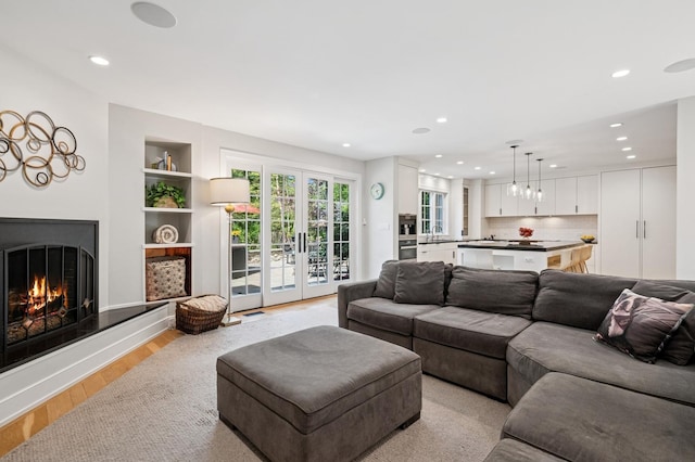 624 Laurel Ave, Wilmette, IL 60091 - living room with recessed lighting, light wood finished floors, a lit fireplace, built in features, and french doors