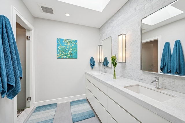 624 Laurel Ave, Wilmette, IL 60091 - bathroom featuring a skylight, double vanity, and recessed lighting