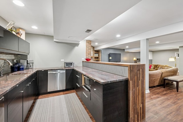 624 Laurel Ave, Wilmette, IL 60091 - kitchen featuring dishwasher, wood finished floors, a peninsula, light stone countertops, and decorative backsplash