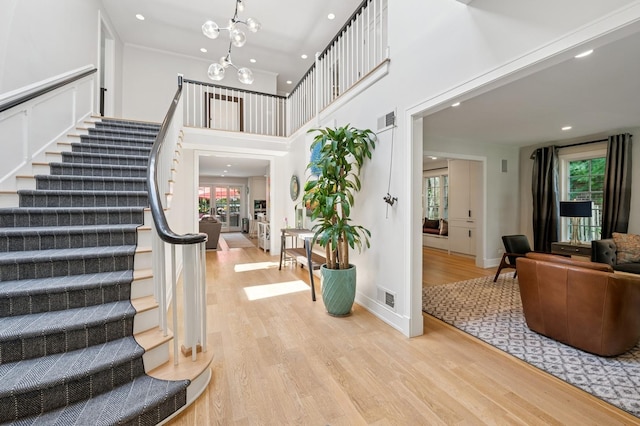 624 Laurel Ave, Wilmette, IL 60091 - stairs with wood finished floors, recessed lighting, a chandelier, and a high ceiling