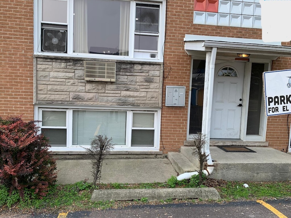 4115 S Harlem Ave Unit Ge, Stickney, IL 60402 - view of exterior entry featuring brick siding, stone siding, uncovered parking, and an AC wall unit