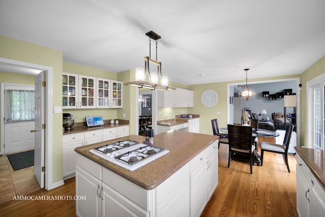 4 Dryden Ct, Algonquin, IL 60102 - kitchen featuring white gas cooktop, glass insert cabinets, light wood finished floors, a kitchen island, and white cabinets