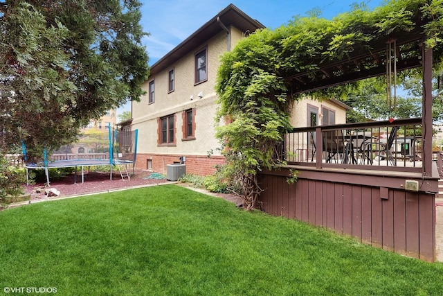 1150 S Oak Park Ave, Oak Park, IL 60304 - rear view of house with a trampoline, a lawn, a deck, and stucco siding