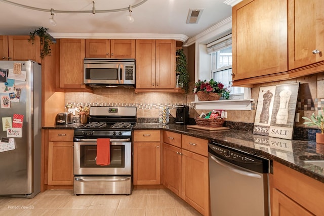 7612 N Rogers Ave Unit G, Chicago, IL 60626 - kitchen with stainless steel appliances, backsplash, dark stone counters, brown cabinetry, and light tile patterned floors