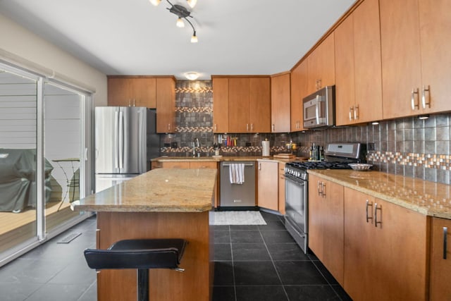 21309 Silktree Cir, Plainfield, IL 60544 - kitchen featuring appliances with stainless steel finishes, dark tile patterned floors, backsplash, and a center island