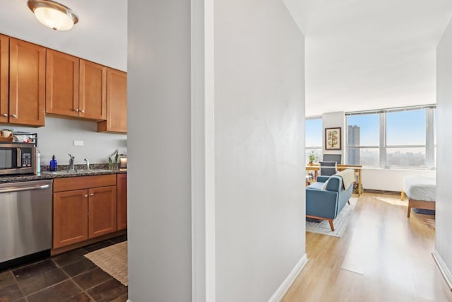 655 W Irving Park Rd Unit 2805, Chicago, IL 60613 - kitchen featuring stainless steel appliances, brown cabinetry, dark stone countertops, dark wood-style floors, and open floor plan