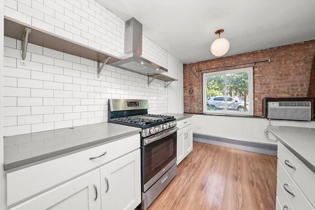 4113 W Cullom Ave Unit 1C, Chicago, IL 60641 - kitchen featuring stainless steel gas range oven, wall chimney exhaust hood, open shelves, backsplash, and white cabinets