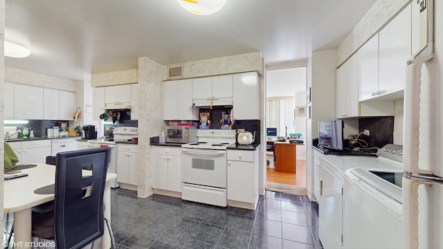 601 E 32nd St Unit 211, Chicago, IL 60616 - kitchen featuring white appliances, tasteful backsplash, washing machine and clothes dryer, dark tile patterned floors, and white cabinetry