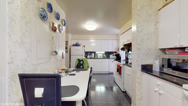 601 E 32nd St Unit 210, Chicago, IL 60616 - kitchen featuring white appliances, white cabinetry, dark countertops, and dark tile patterned floors
