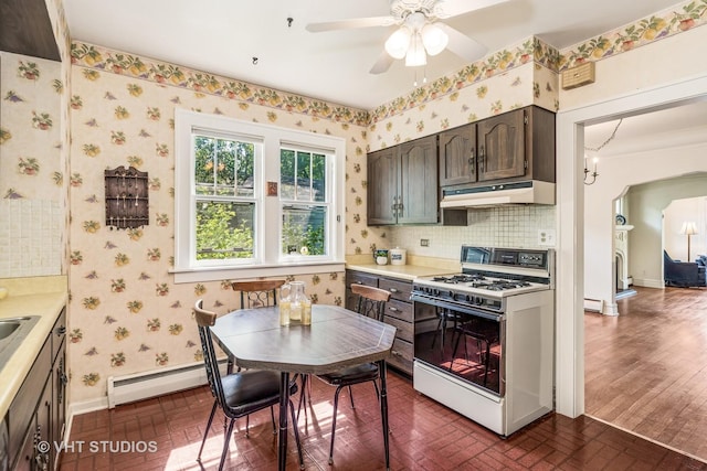 1620 Hyde Park Ave, Waukegan, IL 60085 - kitchen featuring white range with gas cooktop, a baseboard heating unit, under cabinet range hood, ceiling fan, and brick patterned floors