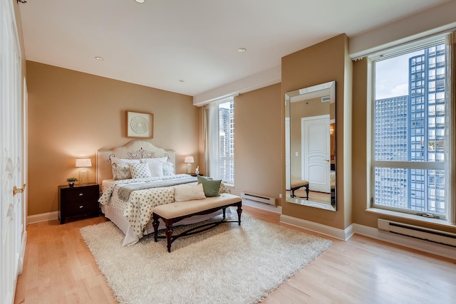 270 E Pearson St Unit 1402, Chicago, IL 60611 - bedroom with a baseboard heating unit and light wood finished floors