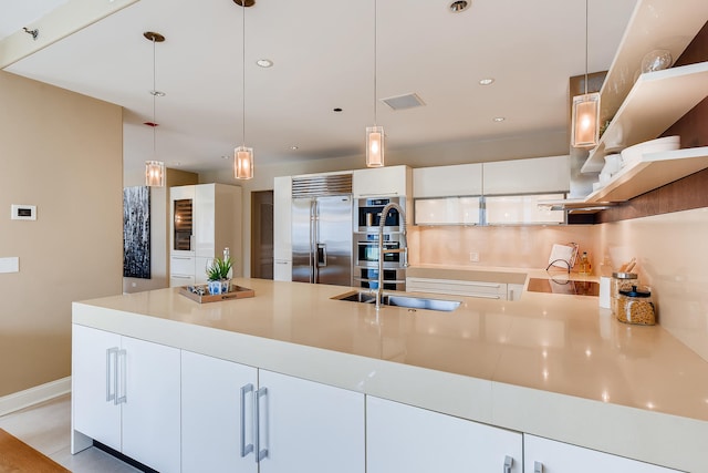270 E Pearson St Unit 1402, Chicago, IL 60611 - kitchen with stainless steel appliances, decorative light fixtures, light countertops, white cabinets, and a peninsula