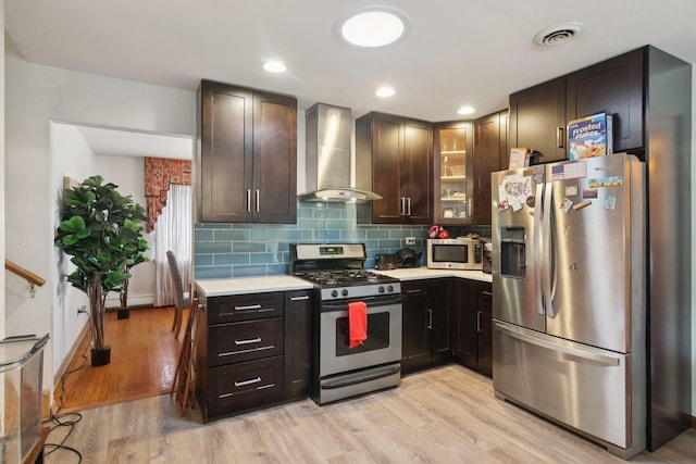 949 E 170th St, South Holland, IL 60473 - kitchen featuring appliances with stainless steel finishes, wall chimney range hood, light countertops, and light wood-style floors