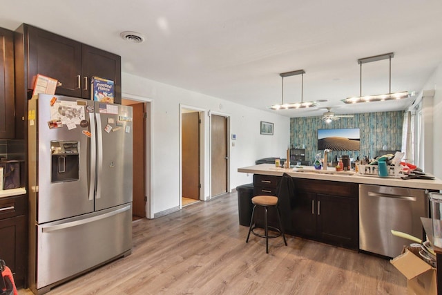 949 E 170th St, South Holland, IL 60473 - kitchen with stainless steel appliances, dark brown cabinetry, light countertops, a ceiling fan, and light wood finished floors