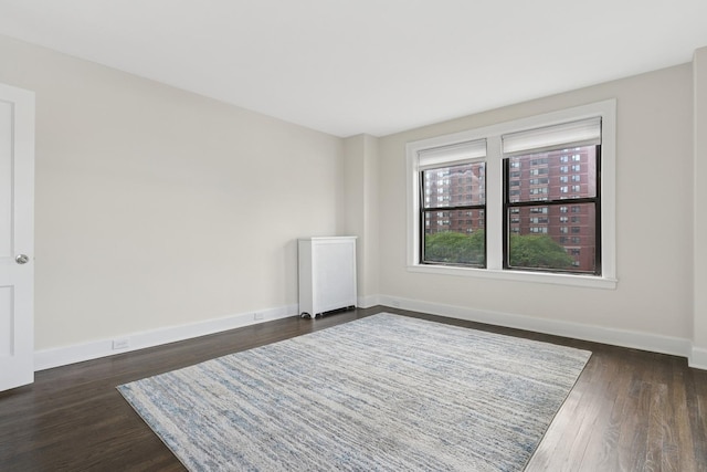1755 E 55th St Unit 503, Chicago, IL 60615 - empty room with radiator heating unit and dark wood-type flooring