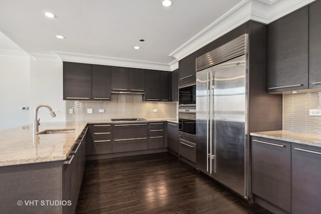 2550 N Lakeview Ave Unit N204, Chicago, IL 60614 - kitchen with built in appliances, dark wood-style flooring, crown molding, a peninsula, and light stone counters