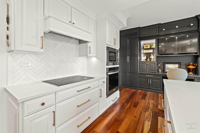 77 S Evergreen Ave Unit 1103, Arlington Heights, IL 60005 - kitchen featuring appliances with stainless steel finishes, premium range hood, backsplash, white cabinets, and light countertops