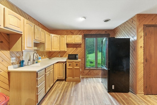 3125 Chellington Dr, Johnsburg, IL 60051 - kitchen with black appliances, light wood-type flooring, wood walls, light countertops, and light brown cabinets