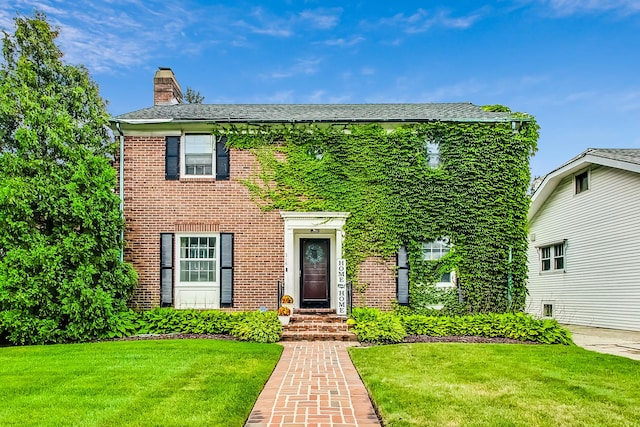 218 N Merrill St, Park Ridge, IL 60068 - colonial inspired home with a chimney, a front yard, and brick siding