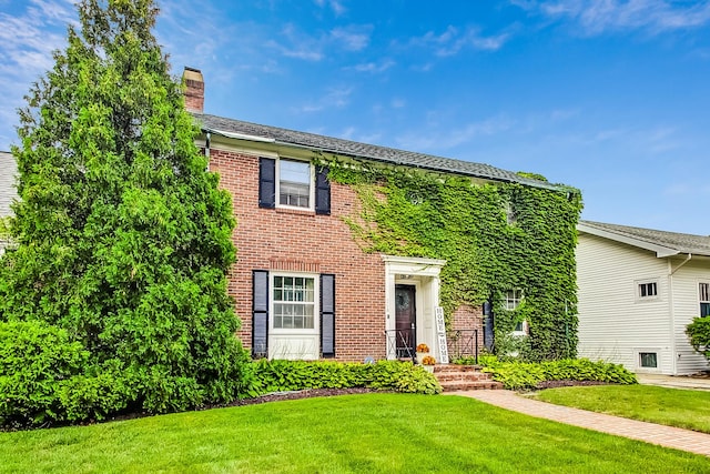 218 N Merrill St, Park Ridge, IL 60068 - colonial house with a front yard, brick siding, and a chimney