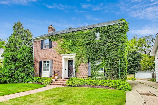218 N Merrill St, Park Ridge, IL 60068 - colonial inspired home with a chimney, a front lawn, and brick siding