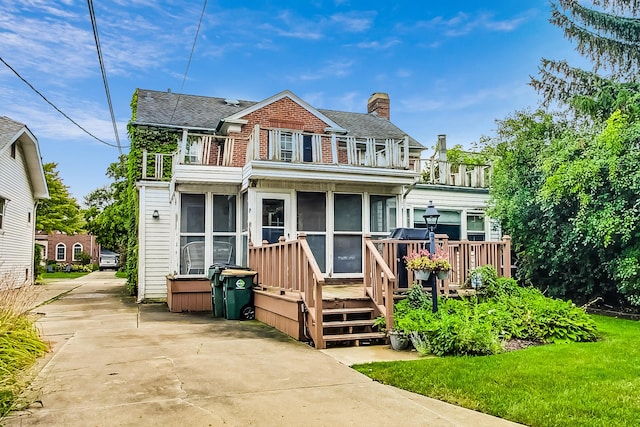 218 N Merrill St, Park Ridge, IL 60068 - view of front of home featuring a balcony, a sunroom, roof with shingles, and a wooden deck