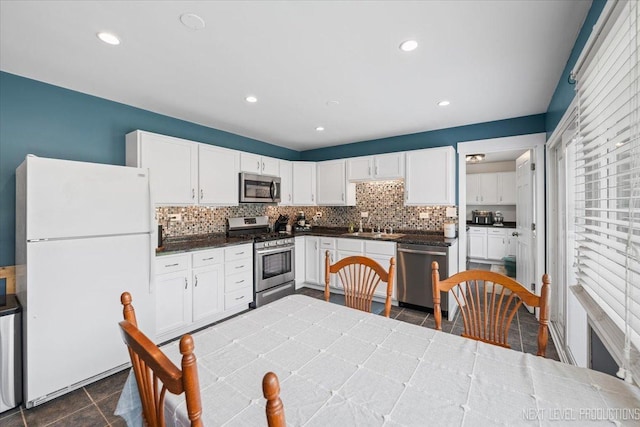 2009 Chaplin Ct, Hanover Park, IL 60133 - kitchen featuring stainless steel appliances, white cabinetry, decorative backsplash, dark tile patterned floors, and recessed lighting