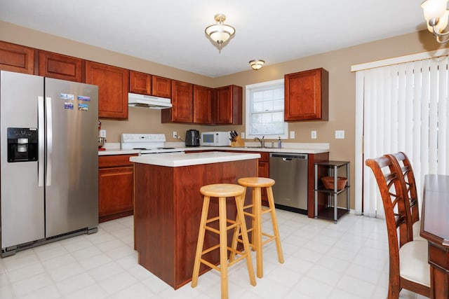 7 Crystal Ct, Bloomington, IL 61704 - kitchen with stainless steel appliances, under cabinet range hood, light floors, light countertops, and a center island
