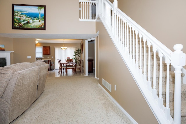 7 Crystal Ct, Bloomington, IL 61704 - staircase with a chandelier, a fireplace, and a towering ceiling