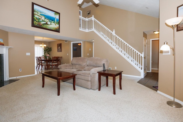 7 Crystal Ct, Bloomington, IL 61704 - carpeted living area featuring stairs, a towering ceiling, a tile fireplace, a chandelier, and ceiling fan