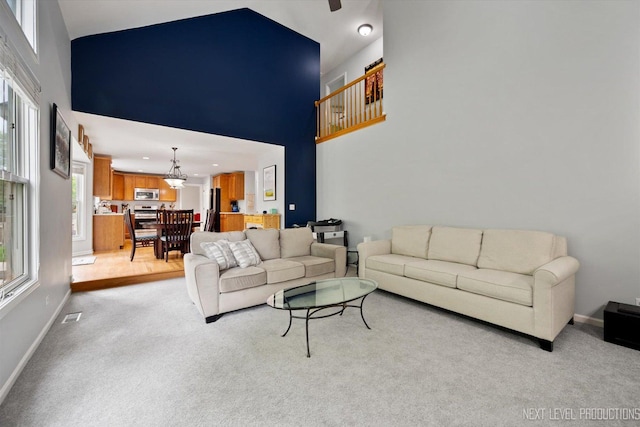 529 Hammer Ln, North Aurora, IL 60542 - living room with a towering ceiling, light colored carpet, a chandelier, and a ceiling fan