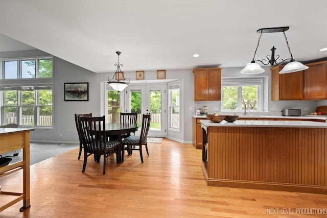 529 Hammer Ln, North Aurora, IL 60542 - kitchen featuring light countertops, french doors, light wood finished floors, pendant lighting, and brown cabinets