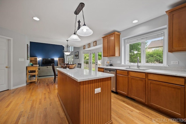 529 Hammer Ln, North Aurora, IL 60542 - kitchen featuring stainless steel dishwasher, a kitchen island, decorative light fixtures, light wood finished floors, and brown cabinetry