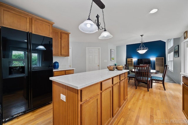 529 Hammer Ln, North Aurora, IL 60542 - kitchen featuring black refrigerator with ice dispenser, light wood-type flooring, brown cabinets, decorative light fixtures, and a kitchen island